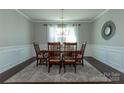 Bright dining room featuring a wooden table, six chairs, elegant chandelier, and large windows with sheer curtains at 246 Sweet Briar Dr, Fort Mill, SC 29707