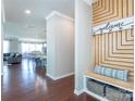 Inviting entryway with wood floors and custom drop zone with bench, storage, and welcome sign at 246 Sweet Briar Dr, Fort Mill, SC 29707