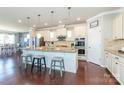 Gourmet kitchen boasts an island with seating, white cabinets, granite countertops, and stainless steel appliances at 246 Sweet Briar Dr, Fort Mill, SC 29707