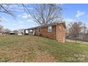 An expansive lawn surrounds this charming brick ranch home with a covered side porch at 2500 Belshire Dr, Conover, NC 28613