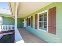 Covered porch with view of the door, window shutters, and exterior finishes at 3863 Shakespeare Dr, Hickory, NC 28601