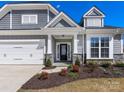 Home exterior with a 2-car garage, black front door, stone accents, and fresh landscaping at 5013 Watercrest Trl, Belmont, NC 28012