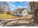 Inviting one-story home with white siding, black shutters, and a long driveway at 502 Crawford St, Shelby, NC 28150