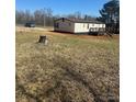 Back view of the home showing a dark deck with stairs into the yard at 8183 Hallman Mill Rd, Vale, NC 28168