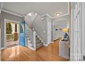 Welcoming entryway with hardwood floors, staircase, and a pop of color with a blue front door at 10011 Roosevelt Dr, Huntersville, NC 28078