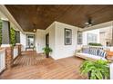 Charming porch with wood flooring, ceiling fan, swing, and decorative plants at 10011 Roosevelt Dr, Huntersville, NC 28078