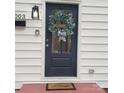 Charming front door with welcome wreath and black-and-white striped bow detail at 1003 Woodland Dr, Gastonia, NC 28054