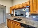 Kitchen featuring wood cabinets and a granite counter, offering a view to the living room at 1022 Mallard Head Ln, Mooresville, NC 28117