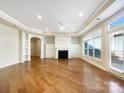 Bright living room featuring hardwood floors, a fireplace and large windows allowing for ample natural light at 1063 Millview Ln, Matthews, NC 28104
