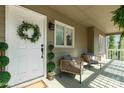 Inviting front porch with seating area, decorative plants, and a charming wreath on the front door at 11 Woodvine Ln, Clover, SC 29710