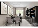 Spacious home office featuring a built-in bookcase, neutral decor, and modern furnishings at 1208 Cottage Green Dr # 0140, Monroe, NC 28112