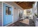 Cozy front porch with seating area, decorative rug, and a charming blue front door at 12304 Huntersville Concord Rd, Huntersville, NC 28078