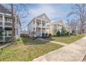 Street view of a two-story home with double porches, a grassy front yard, and sidewalk access at 12304 Huntersville Concord Rd, Huntersville, NC 28078