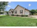 Tan home featuring attached garage and mature landscaping with a sidewalk leading to the front entrance at 1278 Gracebrook Dr, Salisbury, NC 28147
