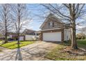 A long driveway leads to a two-car garage on a beautiful home with a well-manicured lawn at 14014 Acorn Creek Ln, Charlotte, NC 28269