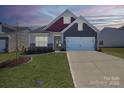 Charming home showcases a well-manicured lawn, stone accents, and a two-car garage at 168 Kennerly Center Dr, Mooresville, NC 28115