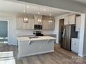 Bright kitchen features an island, stainless steel appliances, and stylish pendant lighting at 1708 Honey Trl, Monroe, NC 28112