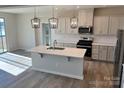 Modern kitchen with island, stainless steel appliances, and elegant pendant lighting at 1708 Honey Trl, Monroe, NC 28112