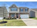 Inviting two-story home with a well-manicured lawn, stone accents, and a two car garage at 181 Atwater Landing Dr, Mooresville, NC 28117