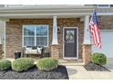 Charming front porch with stone accents, decorative wreath and a bench, offering a warm, inviting welcome at 181 Atwater Landing Dr, Mooresville, NC 28117
