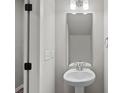 The powder room features a pedestal sink, brushed nickel fixtures, and new paint at 200 Lake George Dr, Shelby, NC 28152