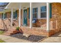 Inviting front porch with brick steps, dark mulch, and a cozy seating area at 2027 Franklin St, Rock Hill, SC 29732