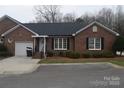 Inviting brick home with an attached one-car garage, complemented by well-maintained landscaping and an attractive front entrance at 2207 Windsor Woods Dr, Gastonia, NC 28054