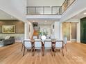 Dining room boasting a large dining table, a double-height ceiling, and hardwood floors at 3416 Windsor Dr, Charlotte, NC 28209