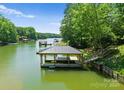 Covered boat dock with access steps, surrounded by lush greenery and tranquil water at 406 Morrison Farm Rd, Troutman, NC 28166