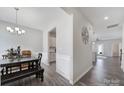 Hallway shot of open-concept dining area features modern lighting, wood flooring, and seamless flow to kitchen and living areas at 4631 Christina Ct, Gastonia, NC 28056
