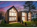 Stunning modern homes showcasing beautiful architecture, large windows, and well-manicured lawns at twilight at 5500 Carmel Rd # 103, Charlotte, NC 28226