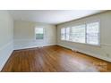 Bright living room features hardwood floors, large windows allowing ample natural light, and neutral wall color at 5536 Seacroft Rd, Charlotte, NC 28210