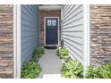 Inviting front entrance featuring a stylish door, stone accents, and lush landscaping at 7456 Hartsfield Dr, Lancaster, SC 29720