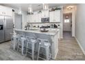 Open kitchen featuring a granite island with seating, stainless appliances, and white cabinetry at 7456 Hartsfield Dr, Lancaster, SC 29720