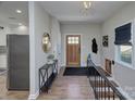 Bright foyer with wood floors, a decorative front door, and convenient coat storage at 7611 Buckland Rd, Charlotte, NC 28278