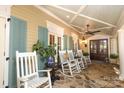 Relaxing covered porch with flagstone flooring, ceiling fan, classic rocking chairs, and craftsman doors at 7794 Live Oaks Dr, Denver, NC 28037