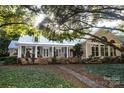 Charming home featuring a covered porch with stone base, classic columns, and a meticulously landscaped yard at 7794 Live Oaks Dr, Denver, NC 28037