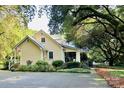 Quaint home surrounded by mature trees and lush landscaping, adding to its charm and curb appeal at 7794 Live Oaks Dr, Denver, NC 28037