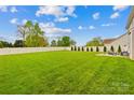 A large, well-maintained backyard enclosed by a white fence, with meticulously arranged greenery at 963 Brookdale Ln, Stanley, NC 28164