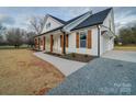 Elegant white home featuring a covered porch with wood columns and shutters, complemented by a well-manicured lawn at 0000 Trull Hinson Rd # 2, Wingate, NC 28174