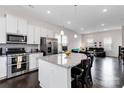 Open kitchen with large island, stainless appliances and dark hardwood floors open to the living room at 1129 Doveridge St, Charlotte, NC 28273