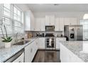 Bright kitchen features white cabinets, granite countertops, stainless steel appliances, and dark hardwood flooring at 1129 Doveridge St, Charlotte, NC 28273