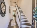 Inviting entryway featuring staircase with dark trim, a decorative rug, and neutral walls at 125 Lanyard Dr # E, Mooresville, NC 28117