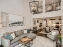 Open-concept living room with high ceilings, a comfortable sofa, and access to dining area and kitchen at 125 Lanyard Dr # E, Mooresville, NC 28117