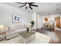 Inviting living room with hardwood floors, a ceiling fan, and access to dining and kitchen at 1525 Walnut View Dr, Charlotte, NC 28208