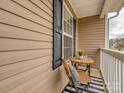 Cozy covered porch with a wicker chair, small table, and black and white striped rug at 163 Brookshire Dr, Fort Mill, SC 29715