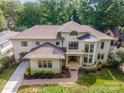 Aerial view of a stunning cream-colored home with a beautiful roof and lush landscaping, offering great curb appeal at 1665 Sterling Rd, Charlotte, NC 28209