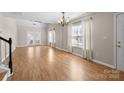 Bright living room with hardwood floors, large windows, and elegant chandelier, perfect for relaxation at 1716 Hidden Creek Dr, Rock Hill, SC 29732