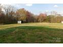 Spacious backyard with a storage building and mature trees at 1909 E Lawyers Rd, Monroe, NC 28110