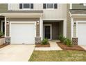 Close-up of a townhome showcasing a garage, front door, and landscaped entry at 2749 Yeager Nw Dr, Concord, NC 28027